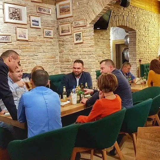 Prieteni ridicând halbele la o masă din Casa cu Bere